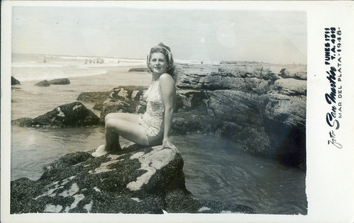 By the sea - One girl on rocks in a one-piece suit