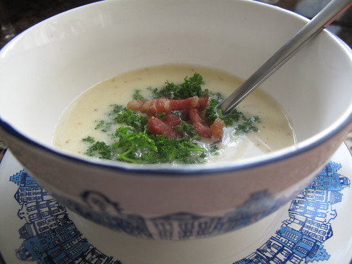 Mustard soup with bacon bits and parsley