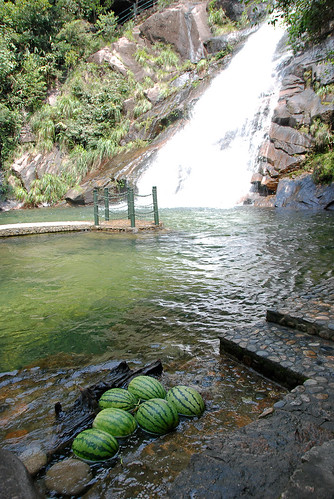 小販把西瓜挑上山，泡在冰涼的溪水裡，用看的就覺得十分消暑解渴