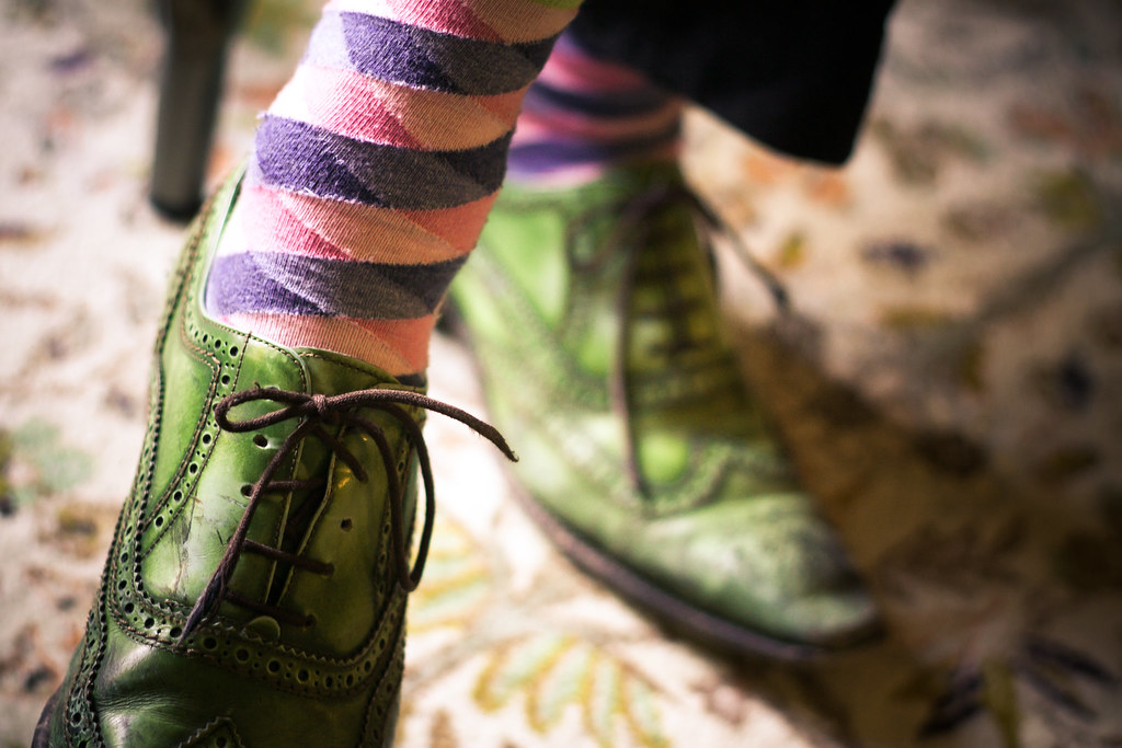 Bright green leather wingtip brogue shoes and colorful striped socks for Kentucky Derby attire.