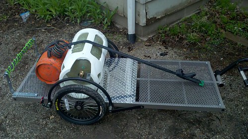 Downward, right side view of a bike trailer with propane tanks loaded on it