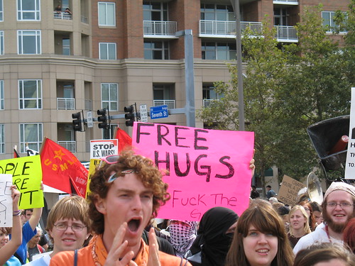 Underneath Free Hugs the sign says: P.S. Fuck the G20