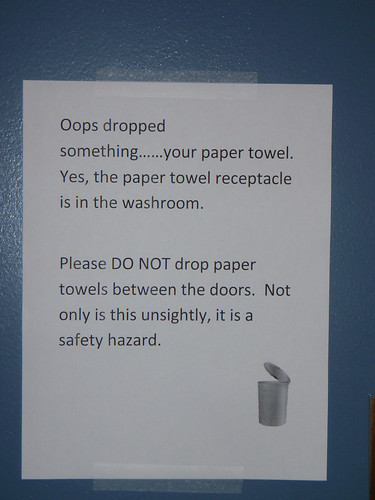 Oops, you dropped something... your paper towel. Yes, the paper towel receptacle is in the washroom. Please DO NOT drop paper towels between the doors. Not only is this unsightly, it is a safety hazard.