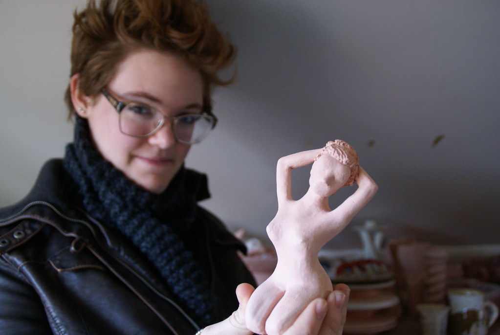 A student hold a clay woman scupture 