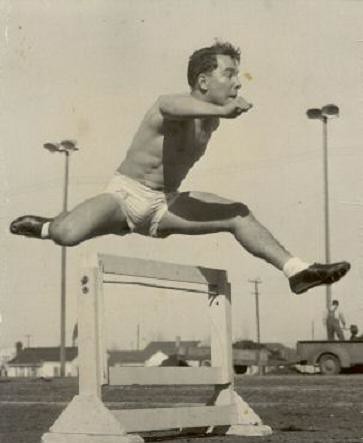 1940s shirtless man athlete track shorts jumping hurdles
