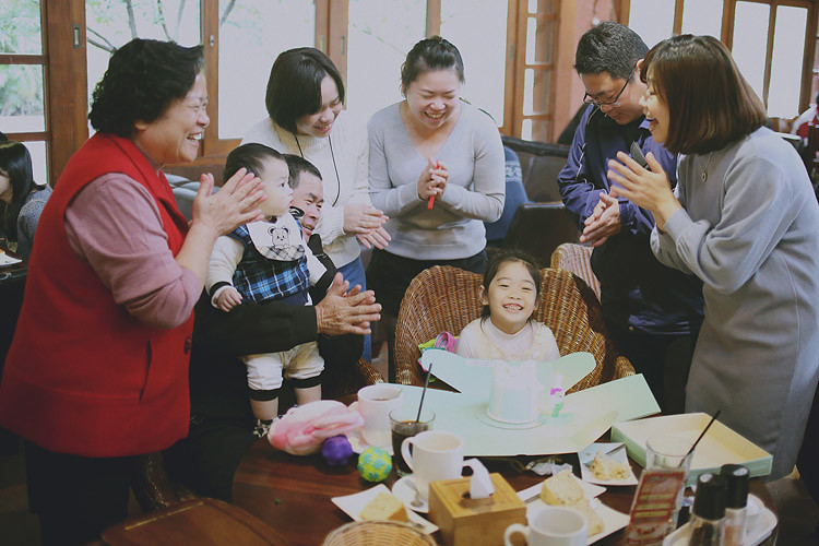 桃園餐廳裡，外公外婆、爸爸媽媽和兩位阿姨圍著生日蛋糕，拍手為姐姐慶生。