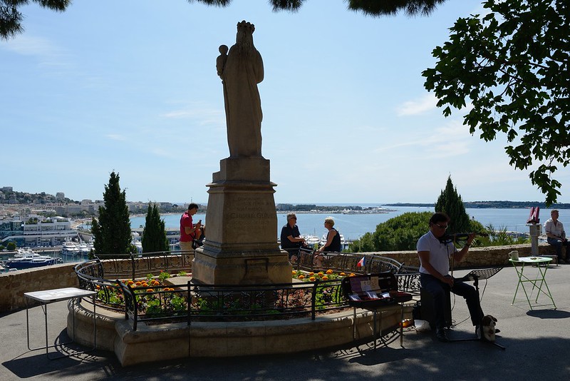 1009-20160524_Cannes-Cote d'Azur-France-upper Place of Old Town beside Eglise Notre Dames d'Esperance-with busker playing violin<br/>© <a href="https://flickr.com/people/25326534@N05" target="_blank" rel="nofollow">25326534@N05</a> (<a href="https://flickr.com/photo.gne?id=33105489332" target="_blank" rel="nofollow">Flickr</a>)