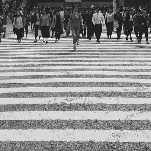 A person leading a group of people through a crosswalk