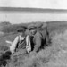 Four Indigenous boys sitting on a grassy hillside, Fort McPherson, Northwest Territories / Quatre garçons indigènes assis sur une colline gazonnée, Fort McPherson (Territoires du Nord-Ouest)